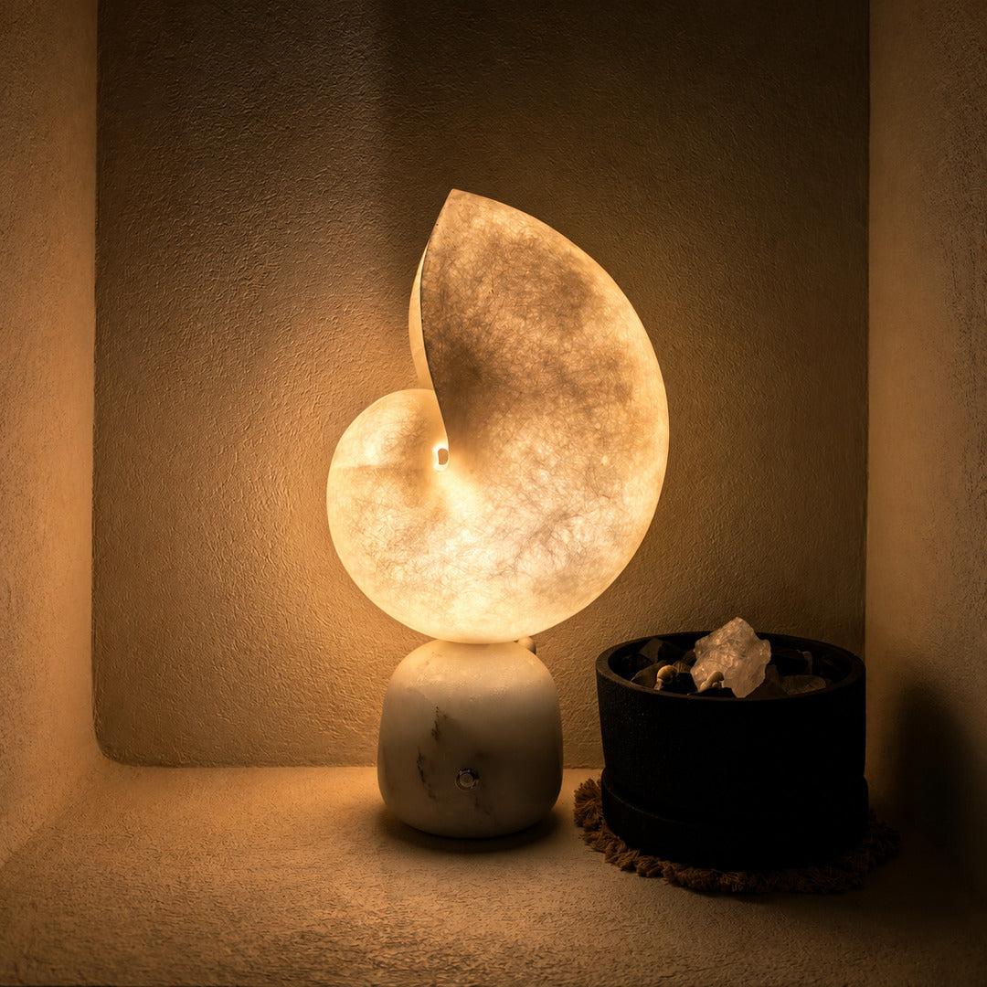 Light fading from bright amber to soft white across the alabaster curve of the Spira lamp