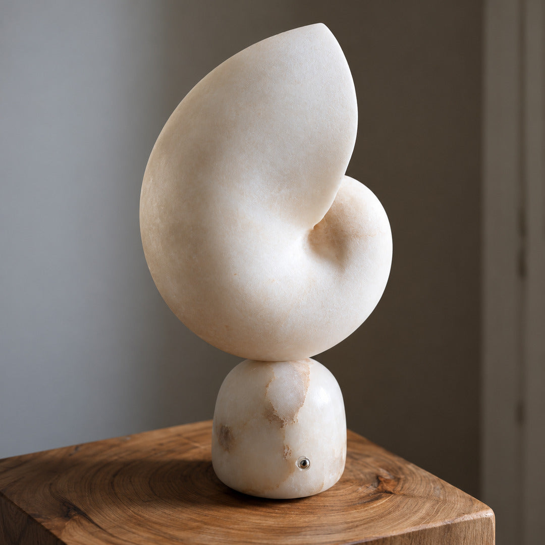 Side view of the Spira alabaster table lamp showing its curled seashell form