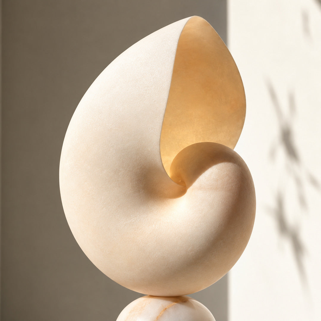 Warm glow escaping from the curled mouth of the Spira alabaster shell lamp