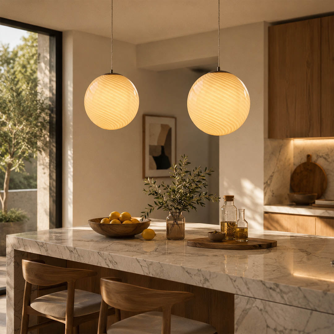 Spira pendant light yellow illuminated warm evening dusk glow modern dining room table centerpiece hand blown spiral ribbed glass sphere honey amber cozy intimate lifestyle interior American home