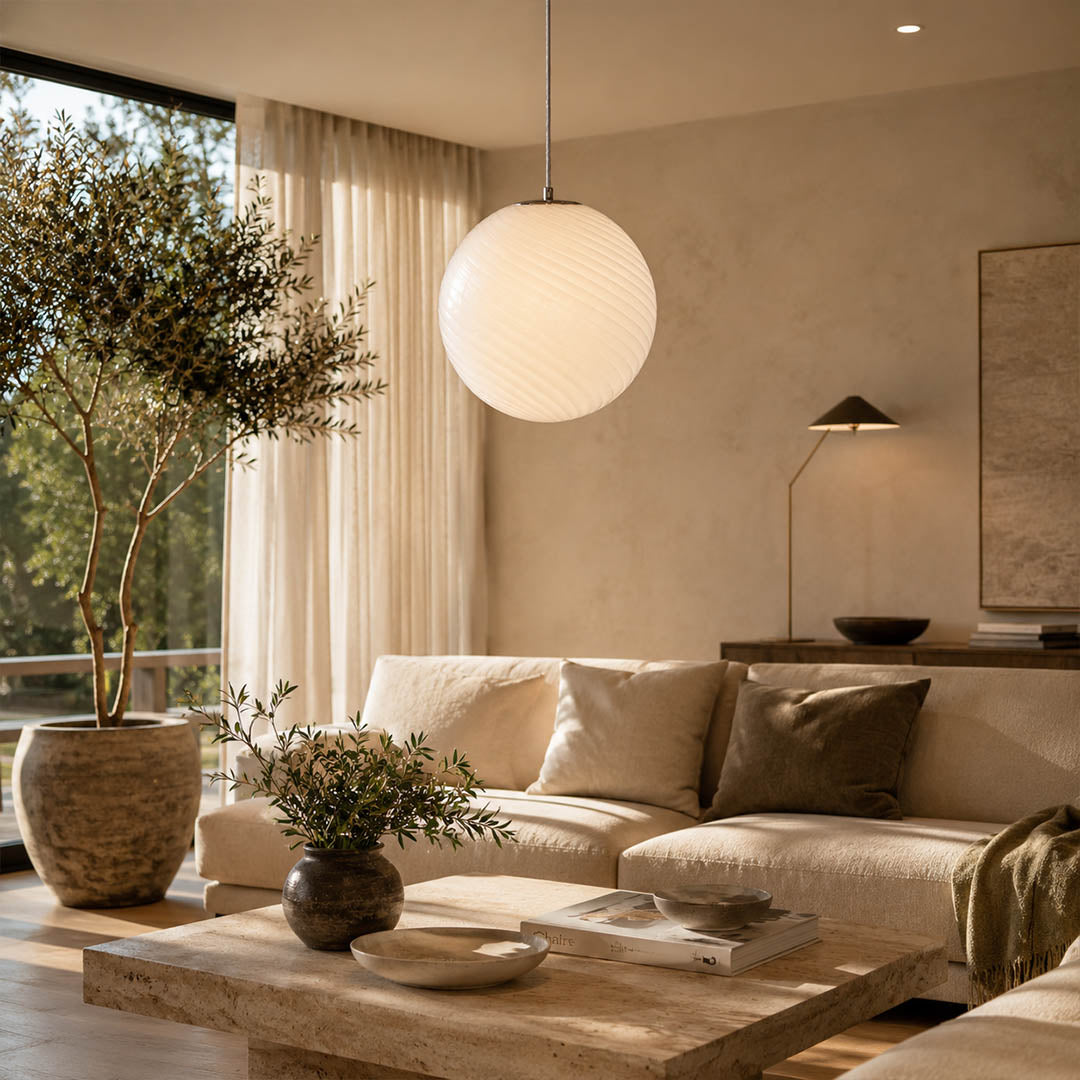 Spira pendant light deep blue single modern living room reading chair corner nook hand blown spiral ribbed glass sphere sophisticated moody warm ambient intimate lifestyle interior American home