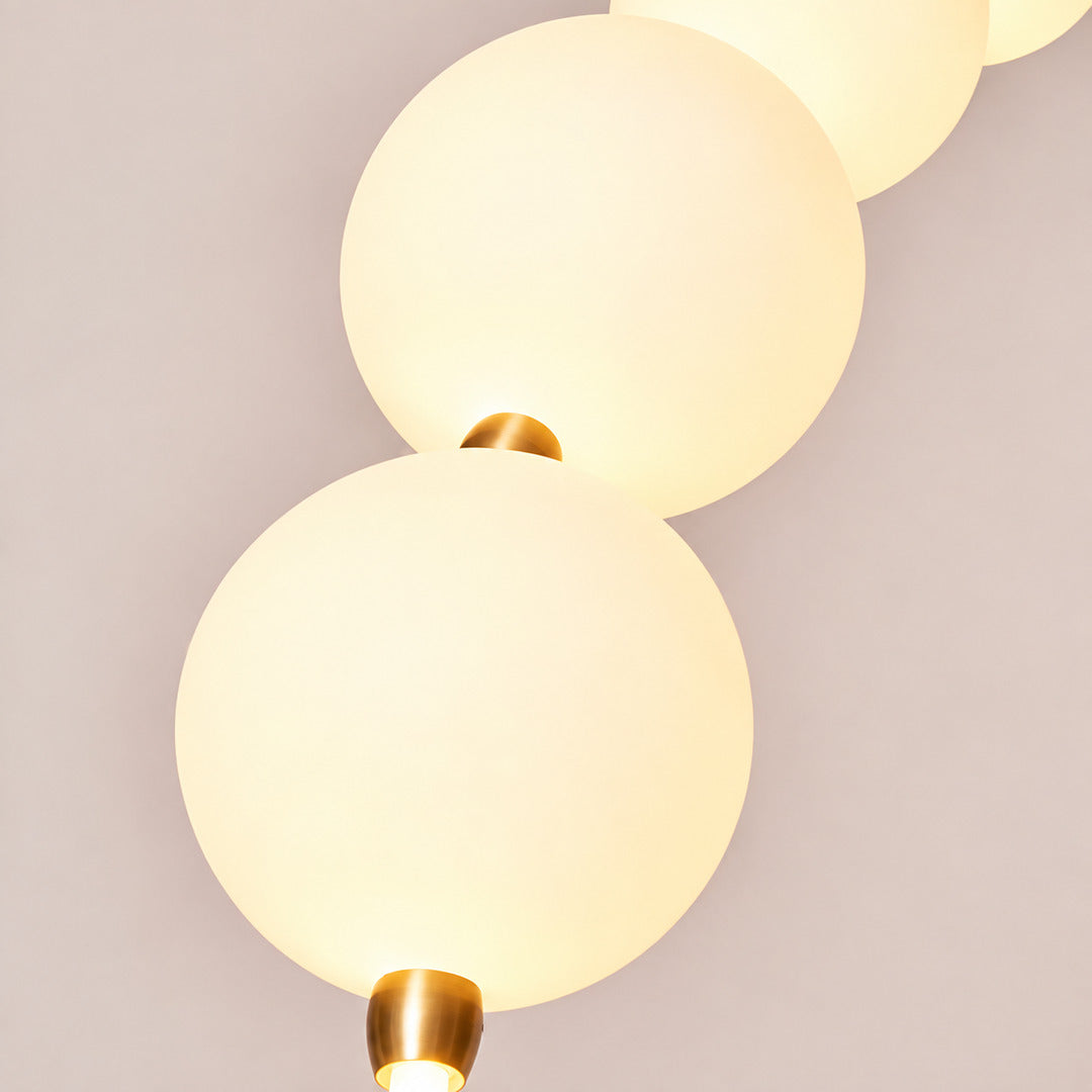 Detail of the arc of frosted glass orbs each glowing warm on the Statue of Liberty floor lamp