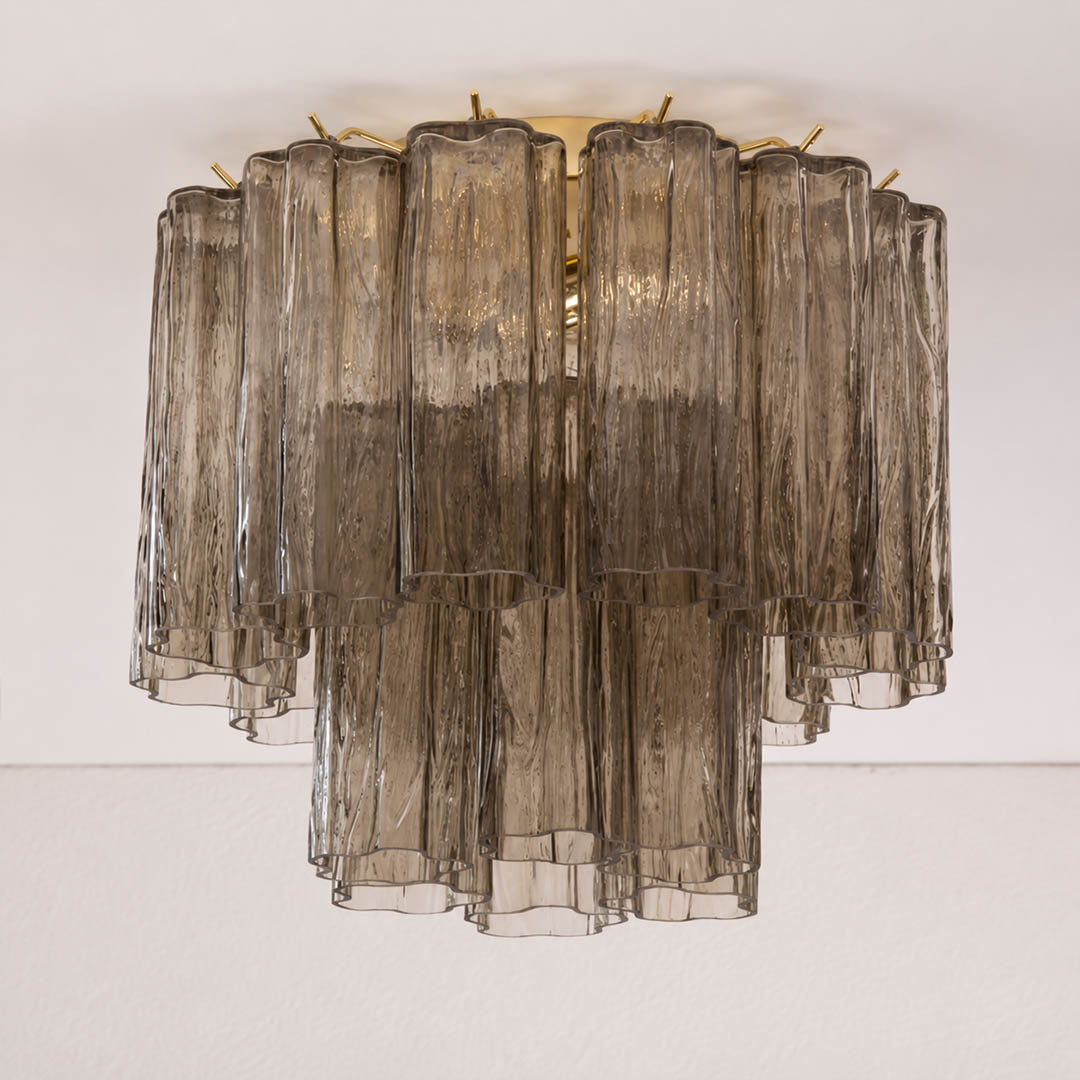 Pure white background, exact Stellina ceiling light with translucent smoky-gray glass and polished gold frame. Light off, centered three-quarter view, realistic transparency and reflections.