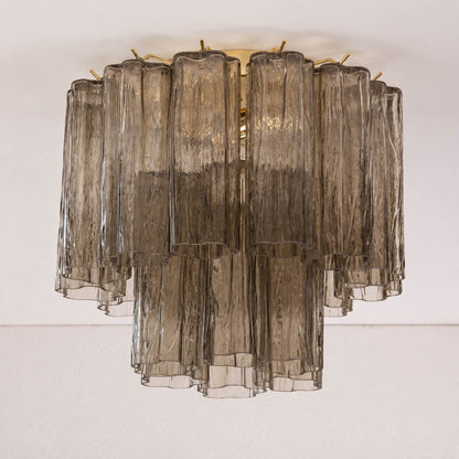 Pure white background, exact Stellina ceiling light with translucent smoky-gray glass and polished gold frame. Light off, centered three-quarter view, realistic transparency and reflections.