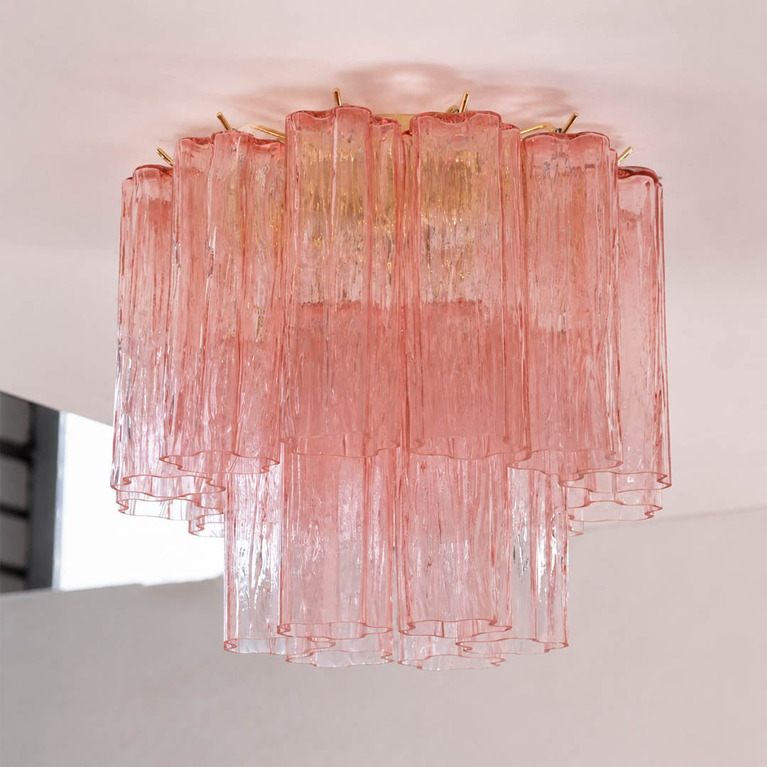 Pure white background, exact Stellina ceiling light with translucent dusty-pink glass and polished gold frame. Light off, centered three-quarter view, realistic material texture, no props or text.