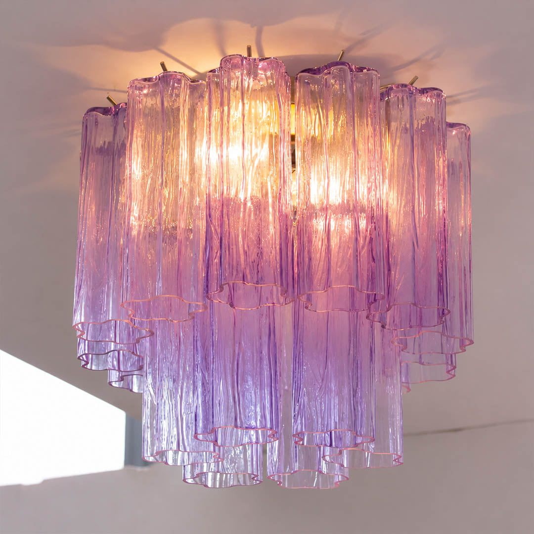 Pure white background, exact Stellina ceiling light with translucent smoky-purple glass and polished gold frame. Light off, centered three-quarter view, no neon color or plastic texture.