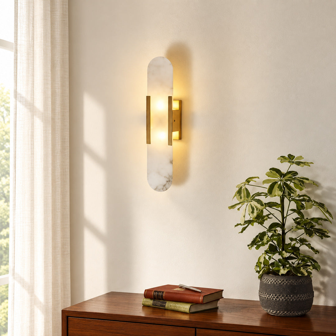 Stilo alabaster wall sconce welcoming guests with a warm vertical glow above an entry console