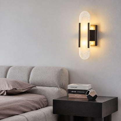 Pair of Stilo alabaster wall sconces flanking a bed for warm symmetrical bedside lighting