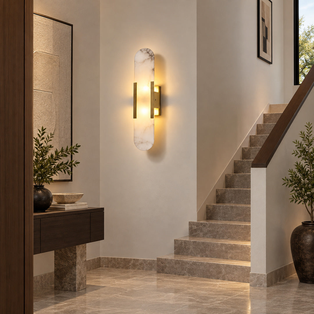 Stilo alabaster wall sconce lighting a staircase wall with a soft vertical natural-stone glow