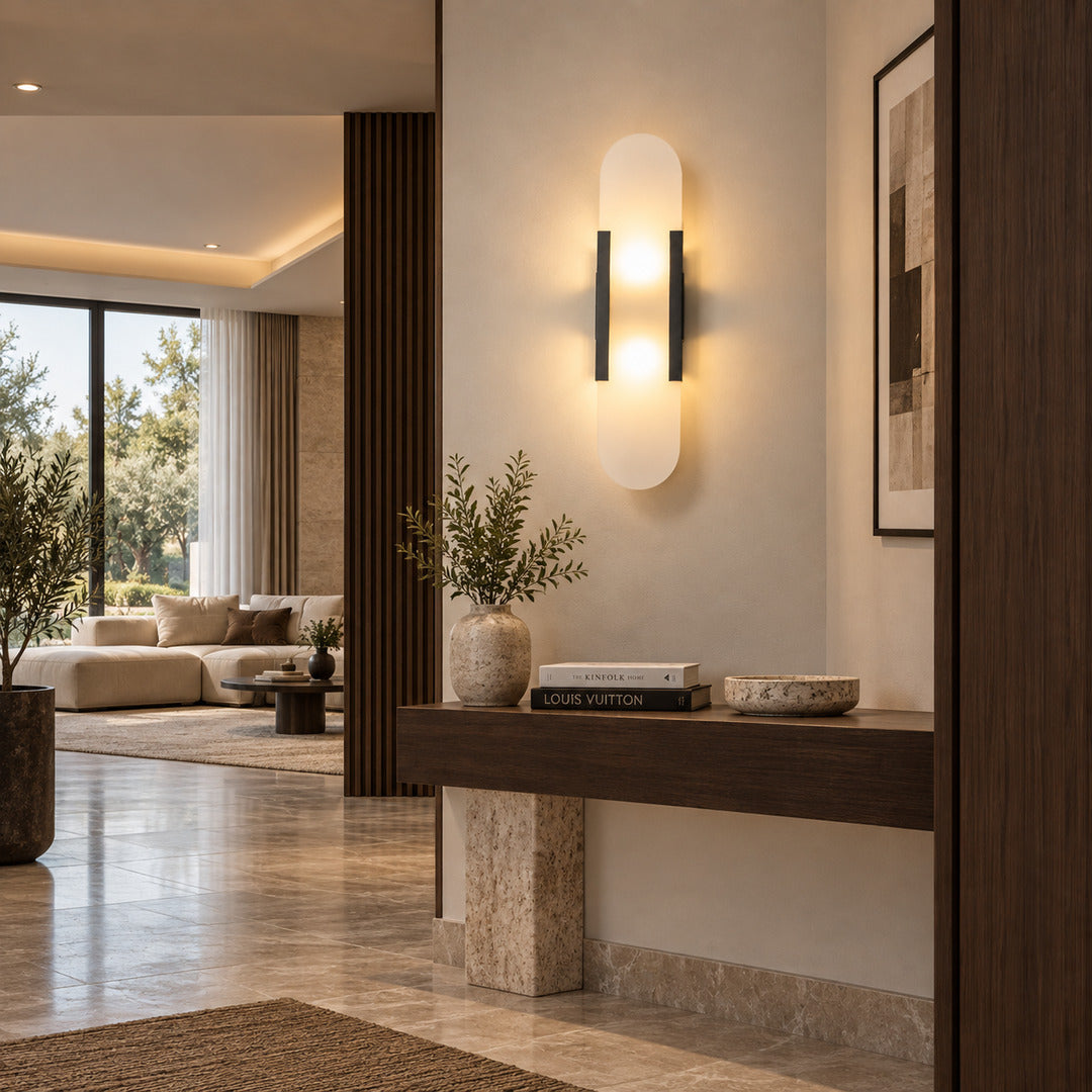 Stilo alabaster wall sconce welcoming guests with a warm vertical glow above an entry console