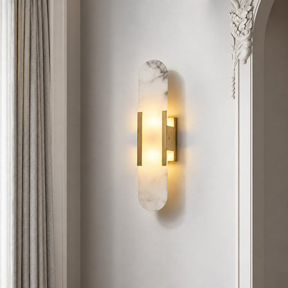 Stilo alabaster wall sconce welcoming guests with a warm vertical glow above an entry console