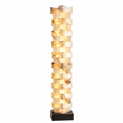 Strato stacked alabaster floor lamp glowing warm in the corner of a modern living room