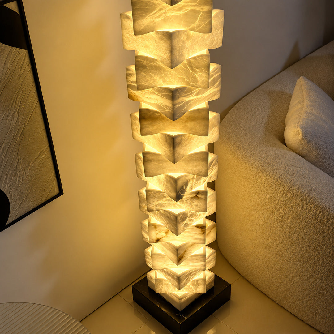 Strato stacked alabaster floor lamp beside a sofa in a modern living room