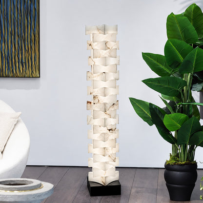Strato alabaster floor lamp beside an armchair in a bedroom reading corner