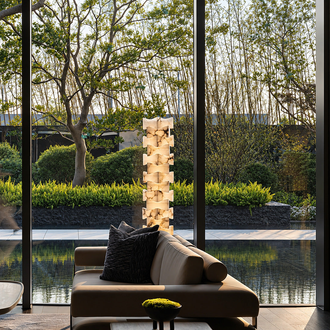 Strato stacked alabaster floor lamp beside a sofa in a modern living room