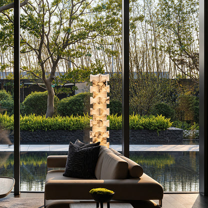 Strato stacked alabaster floor lamp beside a sofa in a modern living room