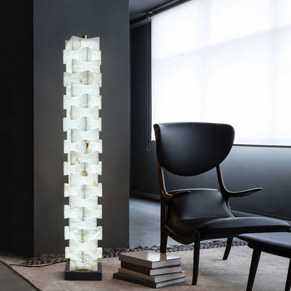 Strato alabaster floor lamp beside an armchair in a bedroom reading corner