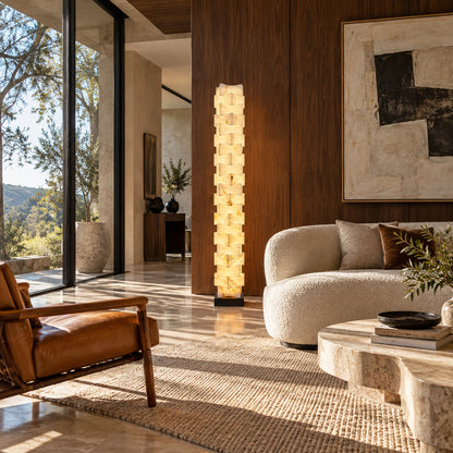 Strato stacked alabaster floor lamp beside a sofa in a modern living room
