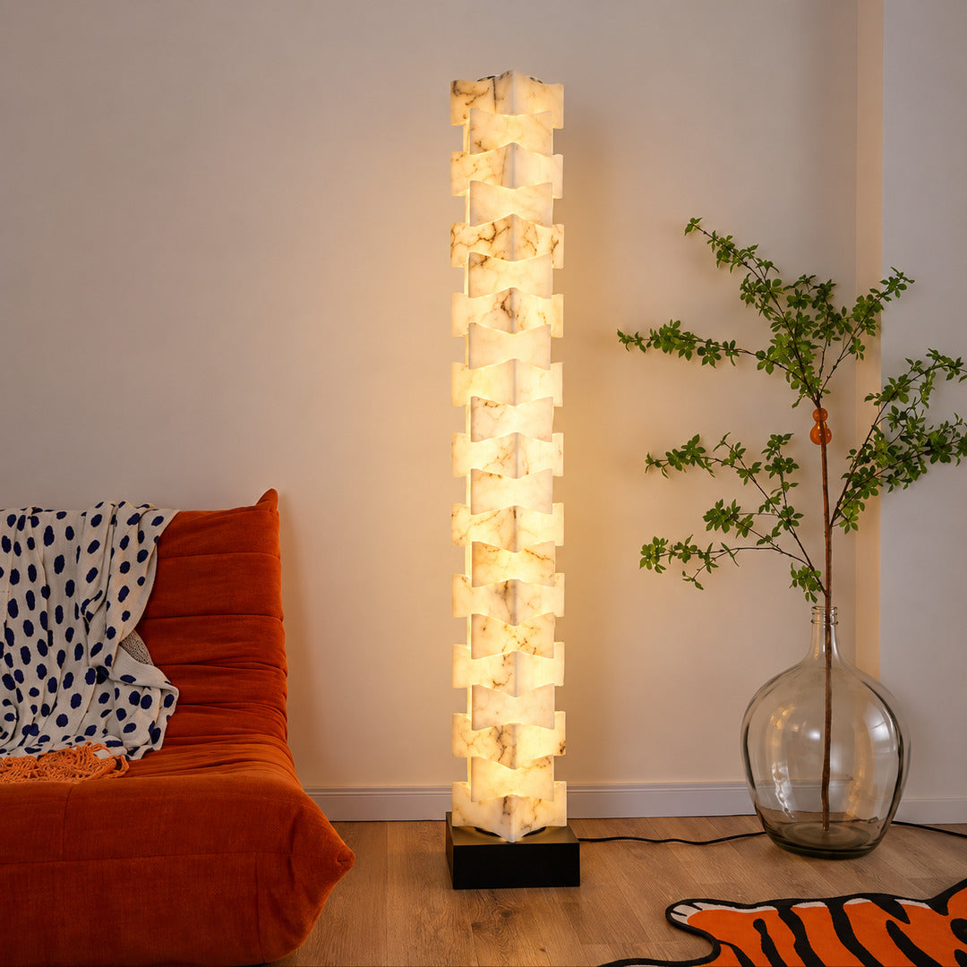 Strato stacked alabaster floor lamp beside a sofa in a modern living room