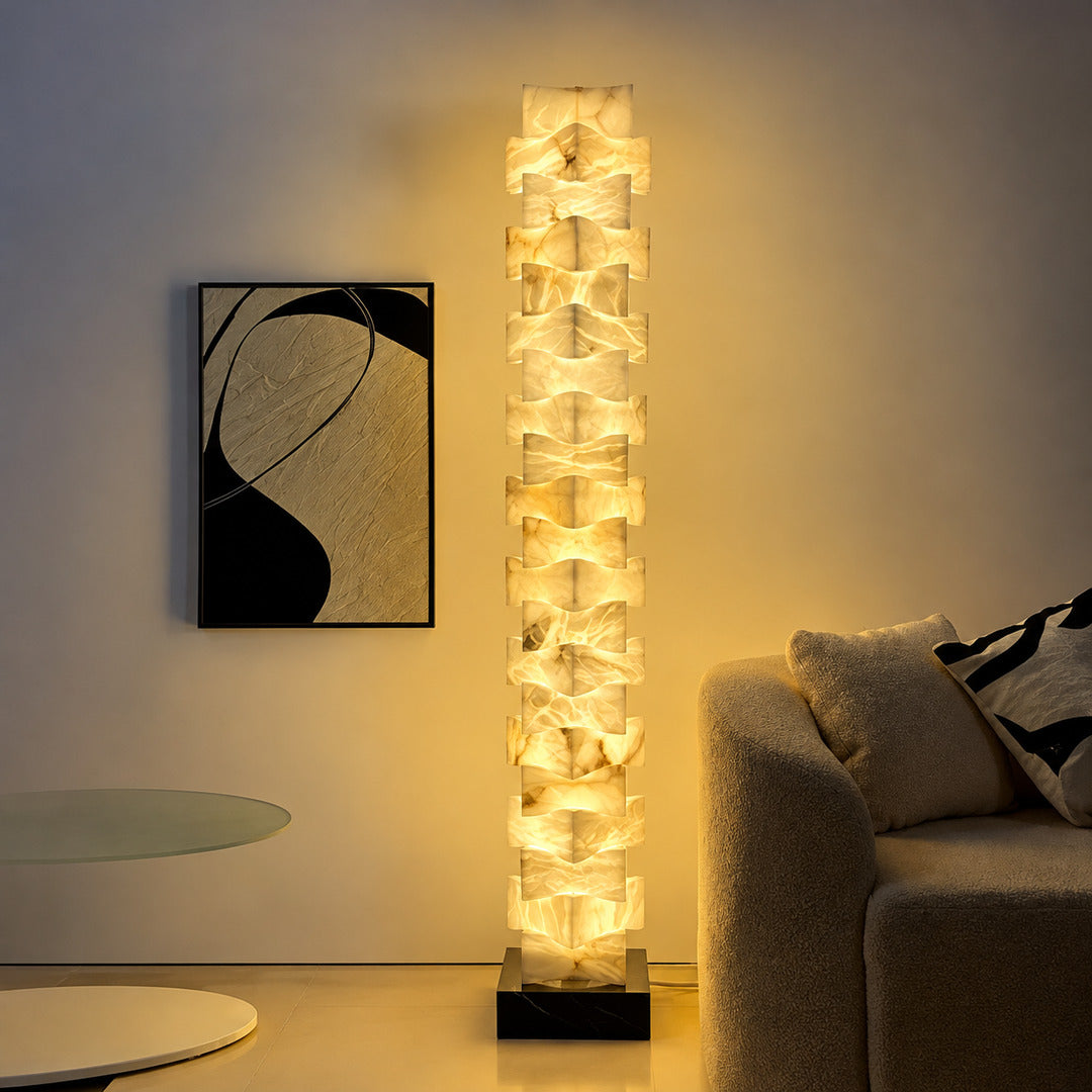 Strato stacked alabaster floor lamp beside a sofa in a modern living room