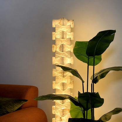 Strato stacked alabaster floor lamp beside a sofa in a modern living room