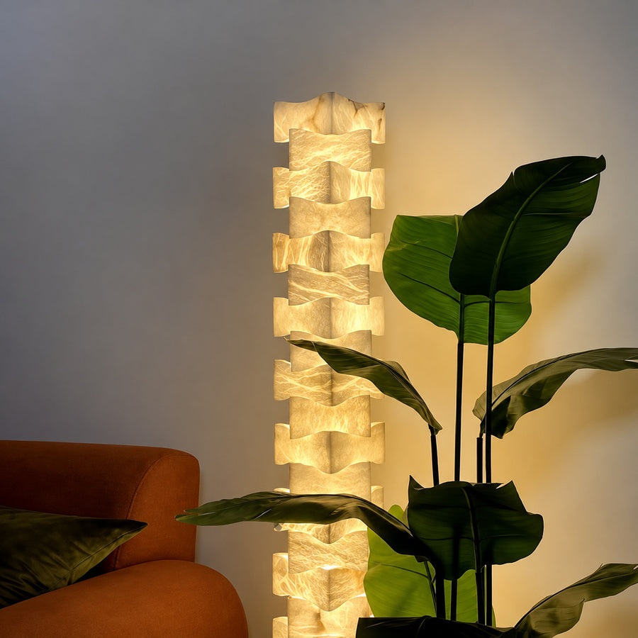 Strato stacked alabaster floor lamp beside a sofa in a modern living room