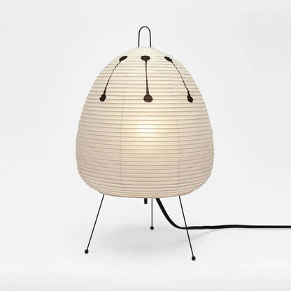 Stuber classic egg-shaped Washi paper table lamp on black tripod legs.