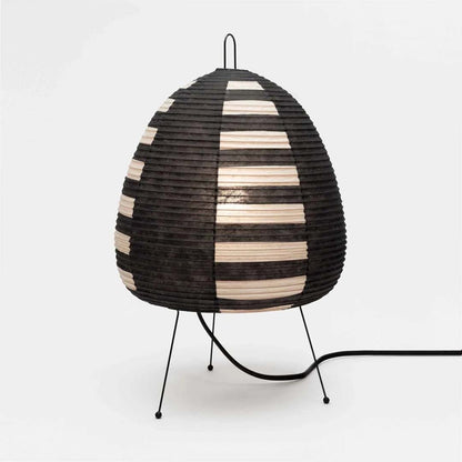 Stuber classic egg-shaped Washi paper table lamp on black tripod legs.