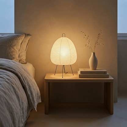 Stuber classic egg-shaped Washi paper table lamp on black tripod legs.