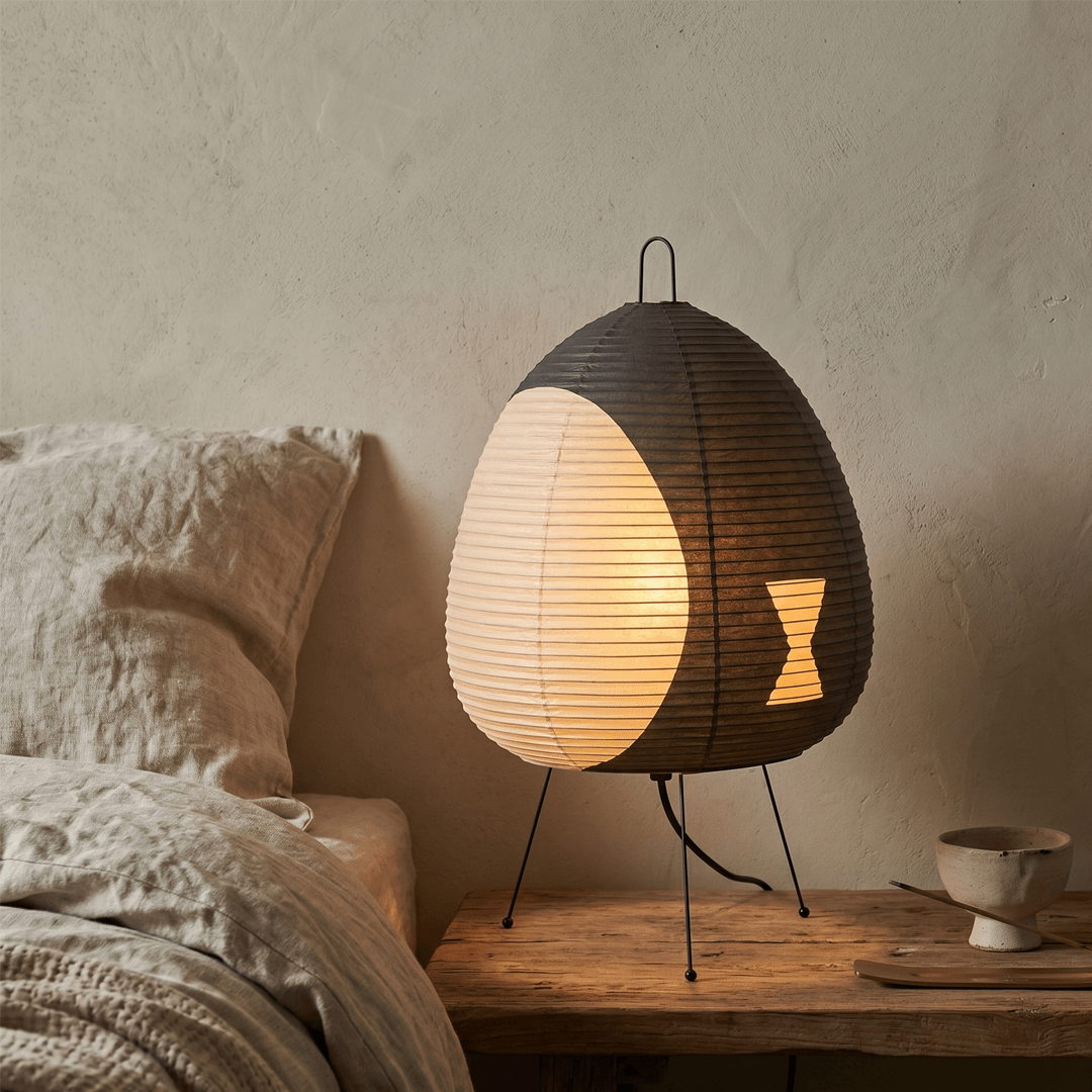 Stuber classic egg-shaped Washi paper table lamp on black tripod legs.