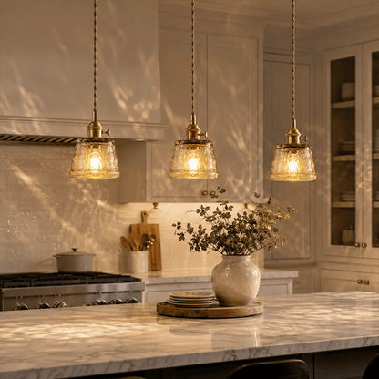 Three amber Nordic Cup pendants above kitchen island marble countertop