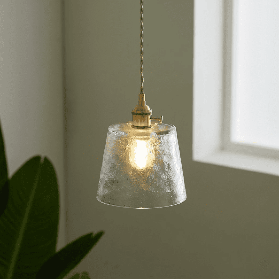 Clear textured glass pendant light hanging near window plant lifestyle