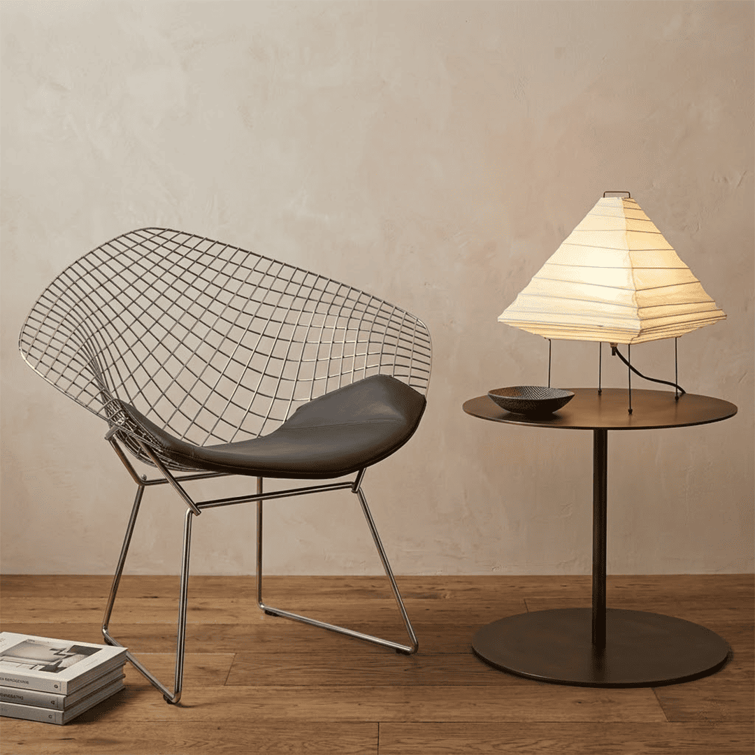 Minimalist modern home lamp: A geometric diamond-shaped washi paper table lamp with a tripod base, emitting a warm glow for cozy interior decoration lighting on a wooden desk.