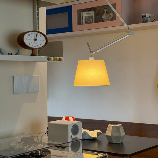 Tate industrial chandelier above home office desk warm parchment glow concrete walls modern minimalist workspace