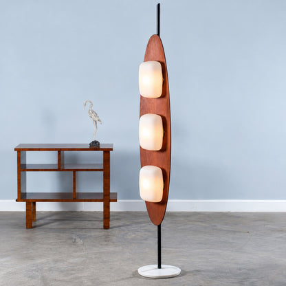 Close-up of the curved teak surfboard-shaped frame of the Tavola wood floor lamp