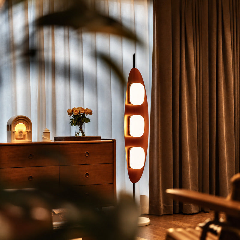 Tavola teak wood floor lamp filling a living room corner with a soft warm glow