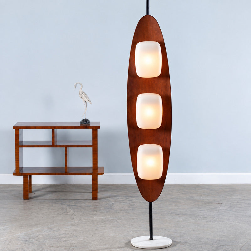 Close-up of the curved teak surfboard-shaped frame of the Tavola wood floor lamp