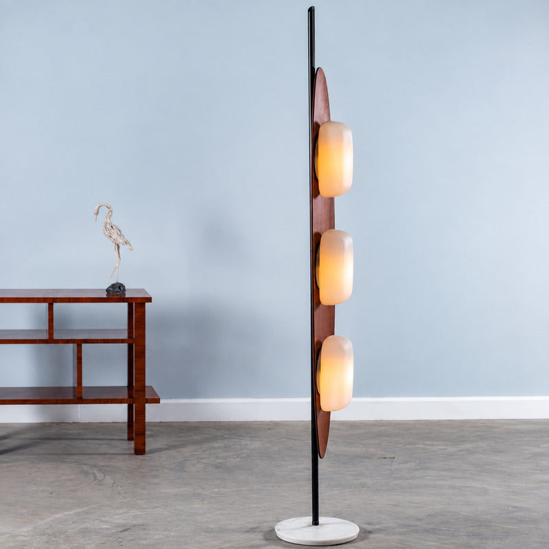 Close-up of the curved teak surfboard-shaped frame of the Tavola wood floor lamp