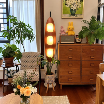 Tavola wood floor lamp casting a soft warm glow over a corner reading chair