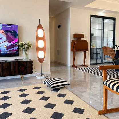 Tavola teak wood floor lamp filling a living room corner with a soft warm glow