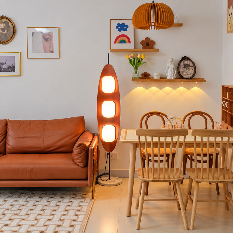 Tavola wood floor lamp standing beside a sofa as a warm sculptural centerpiece in a living room