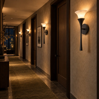Row of Torcia alabaster wall sconces casting warm uplight along a modern hallway