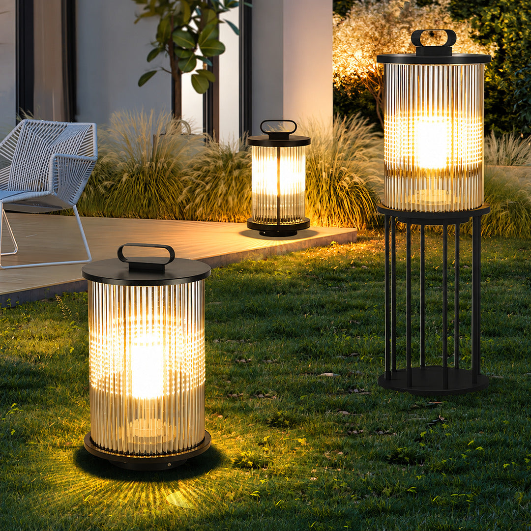 Torre outdoor garden lights lining a garden lawn with a warm cylindrical glow at dusk