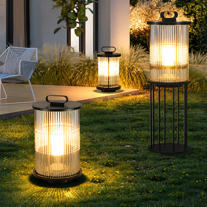 Torre outdoor garden lights lining a garden lawn with a warm cylindrical glow at dusk