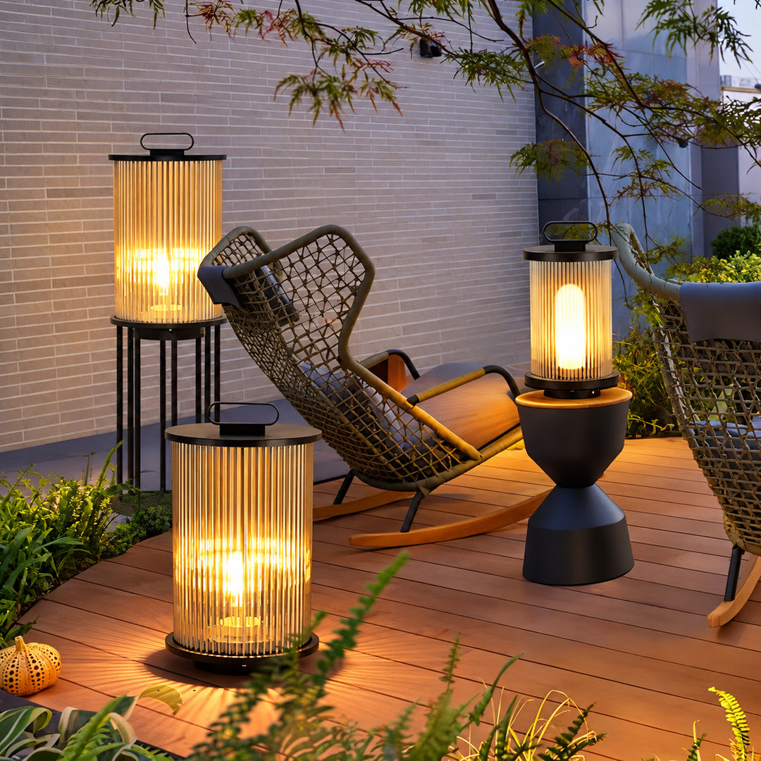 Torre outdoor garden lights lining a garden lawn with a warm cylindrical glow at dusk
