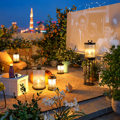 Torre outdoor garden lights lining a garden lawn with a warm cylindrical glow at dusk