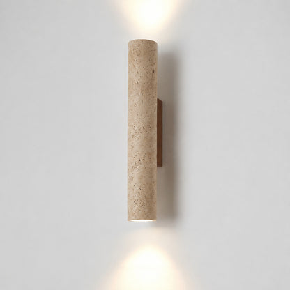 Torre travertine wall sconce illuminated warm amber glow natural travertine stone column wall white background