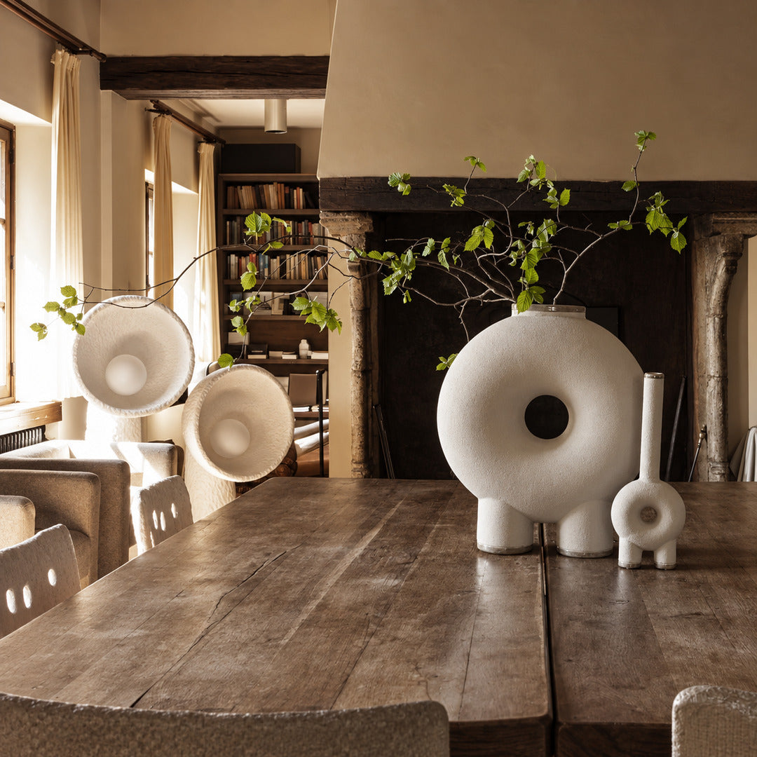 Totem sculptural floor lamp filling a living room corner with a soft warm glow