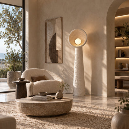 Totem sculptural floor lamp casting a soft warm glow over a corner reading chair
