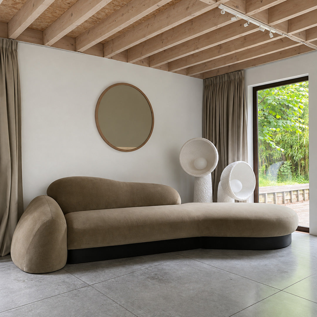 Totem sculptural floor lamp standing beside a sofa as a soft sculptural accent in a living room
